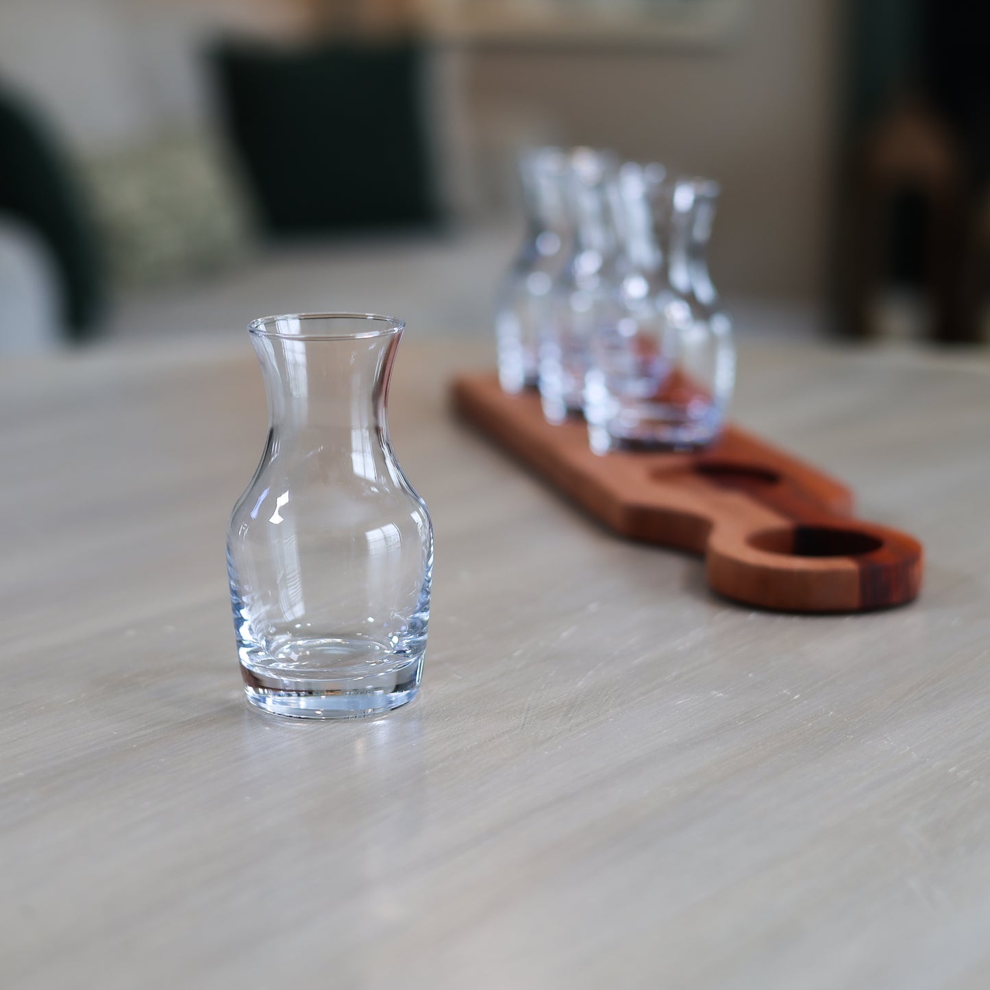 Side view of wine flight board with glass carafes for tasting and serving