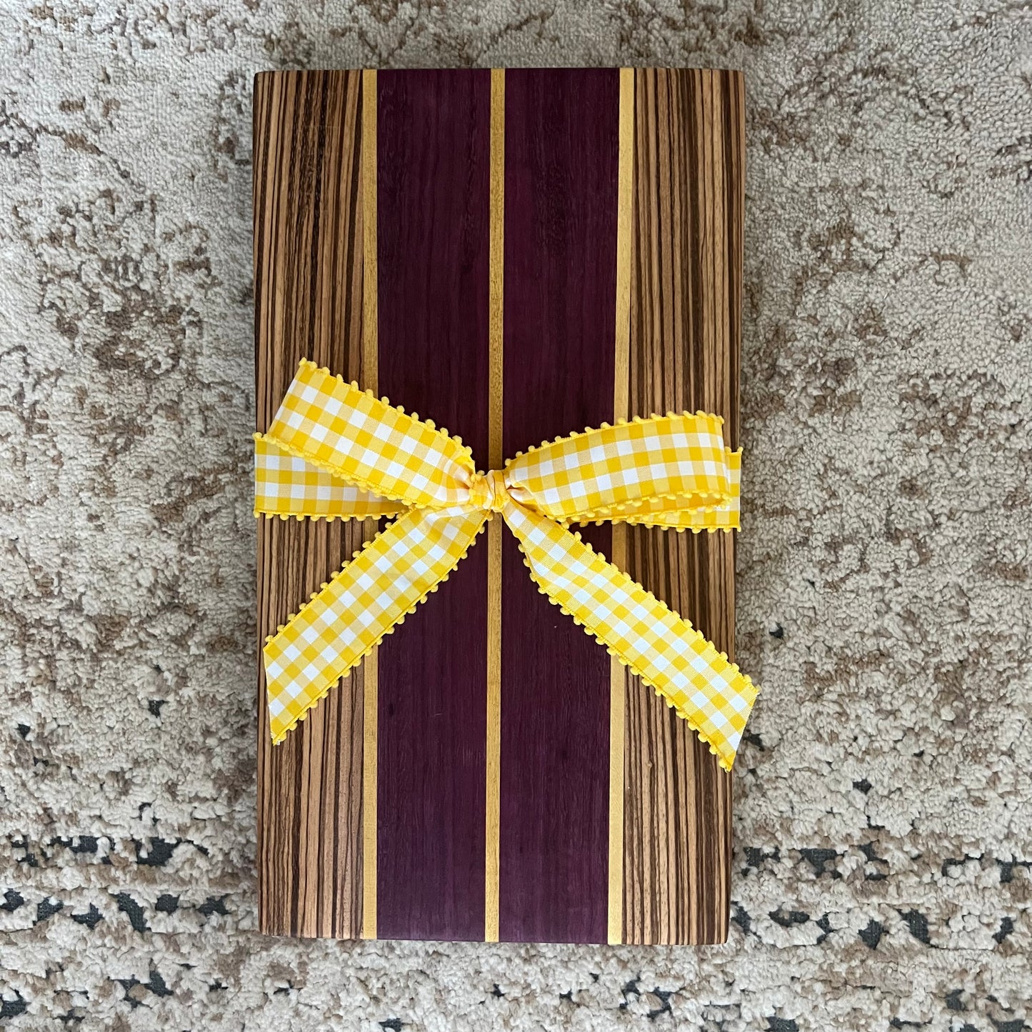 15.75 x 8.75 handcrafted charcuterie board made from purpleheart, zebrawood, and yellowheart with striking wood grain and color contrast.