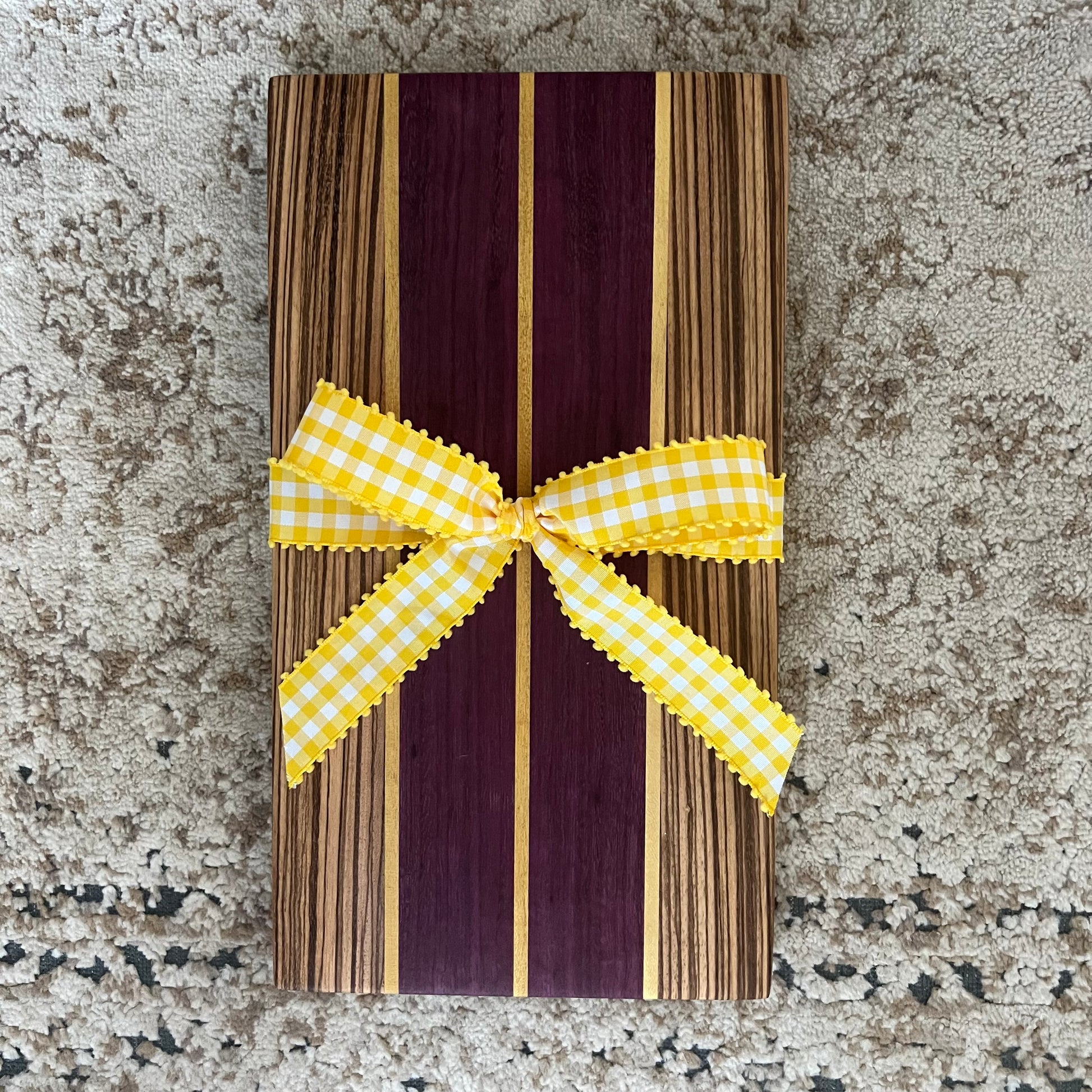 15.75 x 8.75 handcrafted charcuterie board made from purpleheart, zebrawood, and yellowheart with striking wood grain and color contrast.