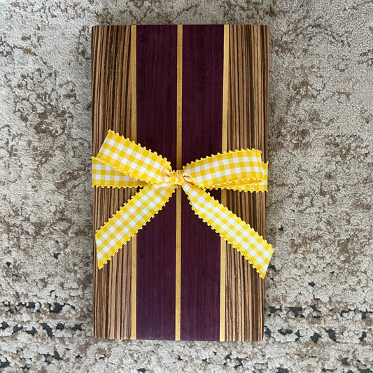 15.75 x 8.75 handcrafted charcuterie board made from purpleheart, zebrawood, and yellowheart with striking wood grain and color contrast.