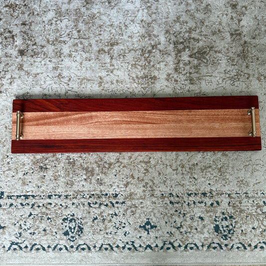 Wooden tray with metal handles on a textured surface