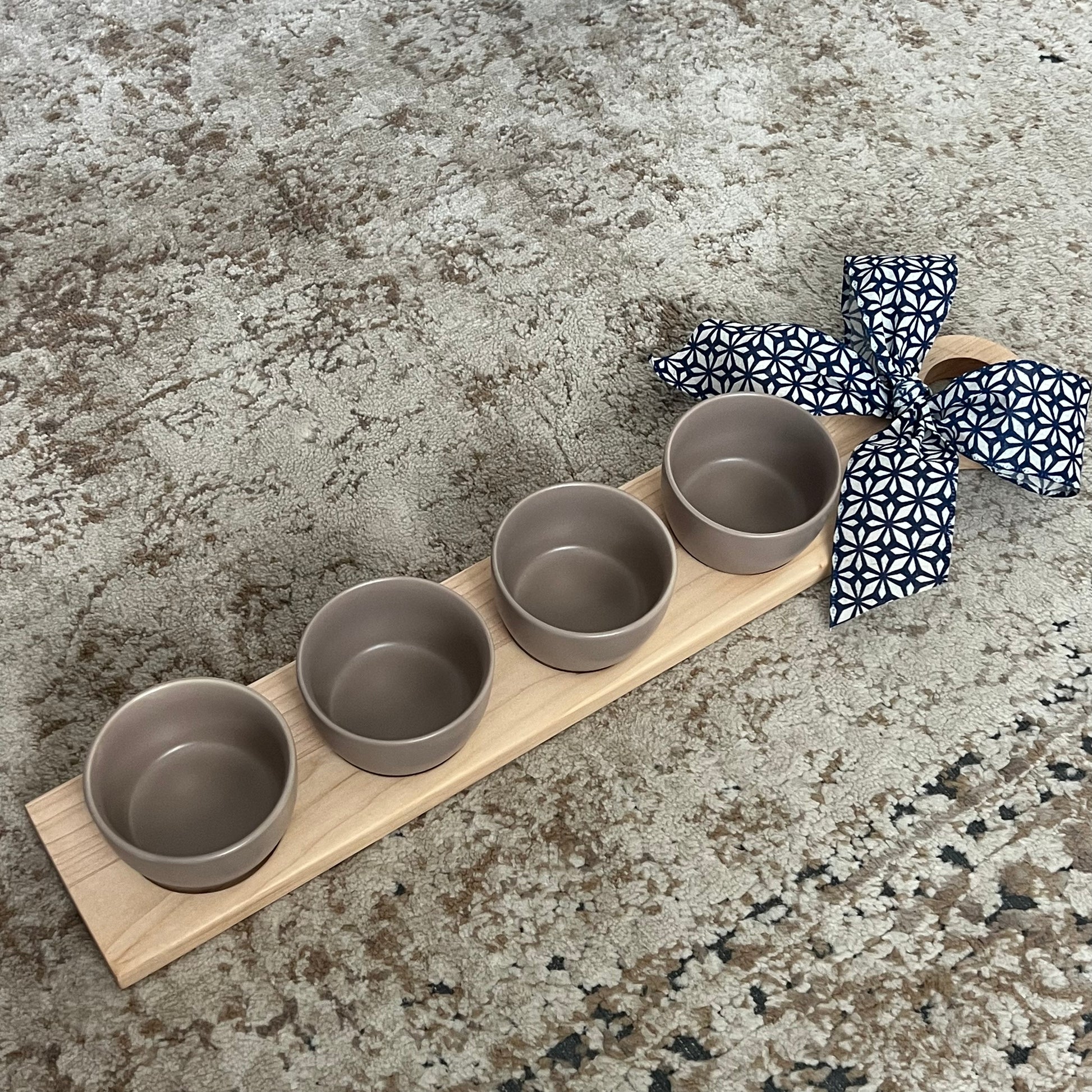 Cherry and maple wood flight board with four tan glass dipping bowls, approximately 24 inches long, handcrafted with smooth finish.