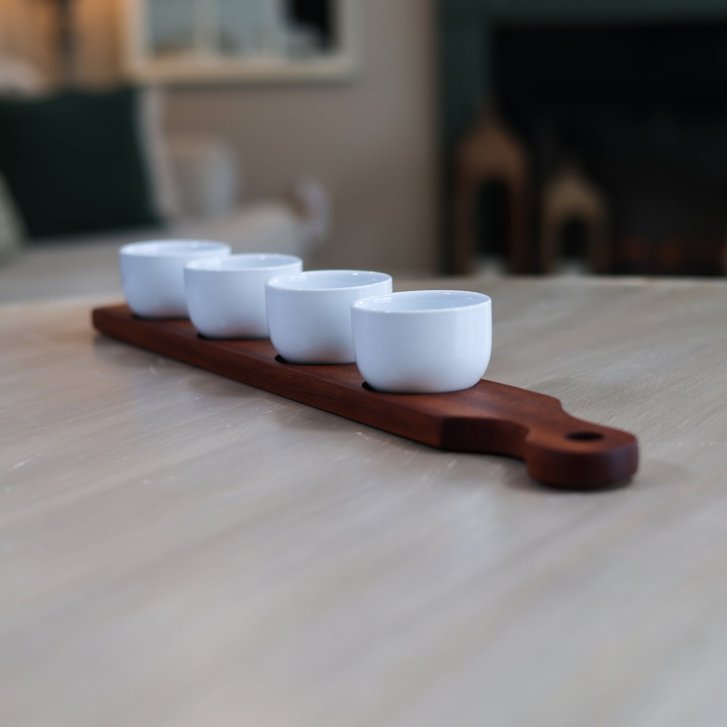 Cherry and maple serving flight with four white dipping bowls arranged on wooden board