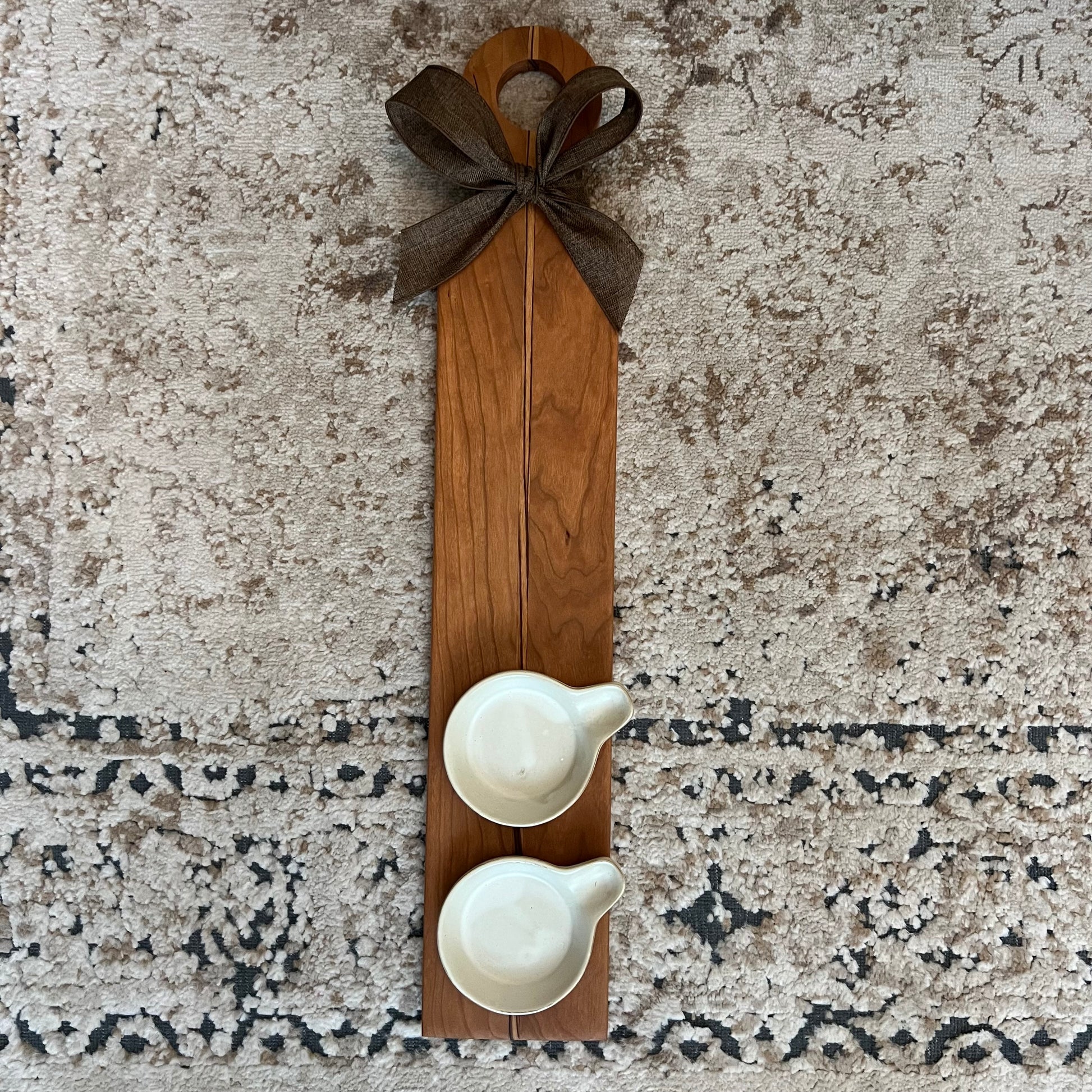 23.5-inch cherry and zebrawood flight board with two white ceramic ramekins and a dark brown bow
