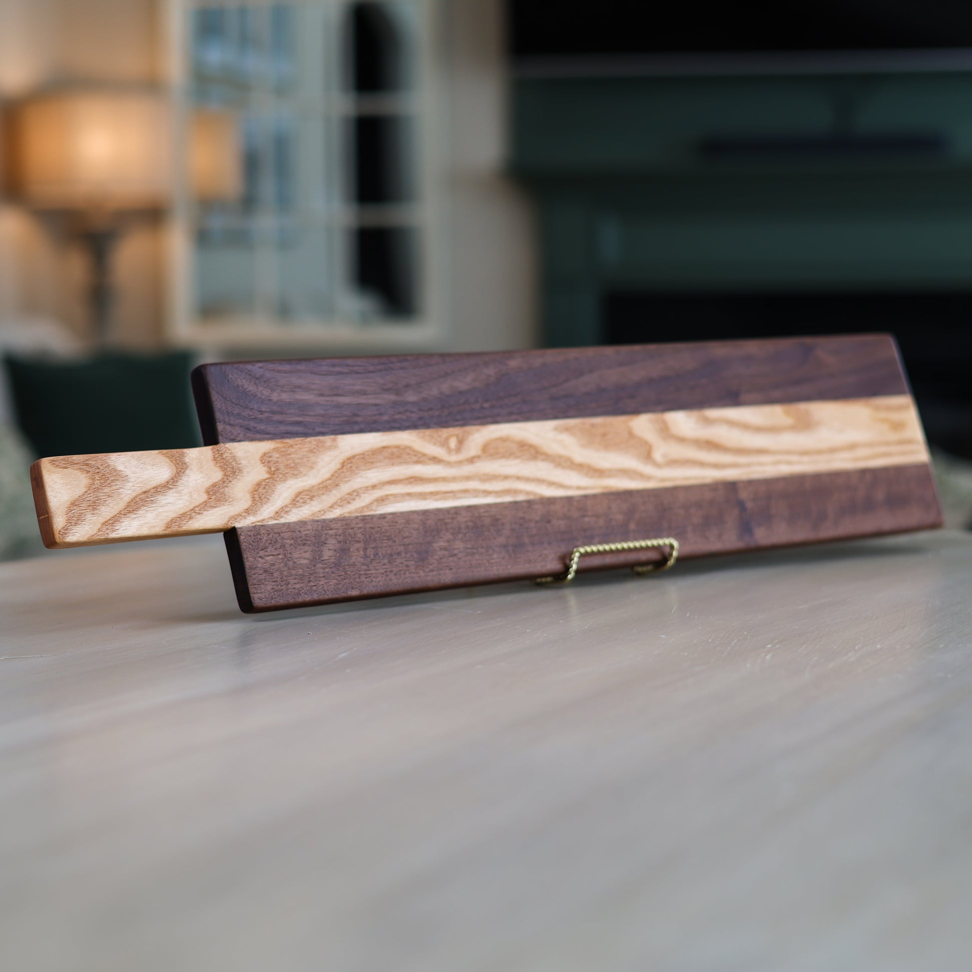 Wooden charcuterie board with two distinct wood types on a table in a living room