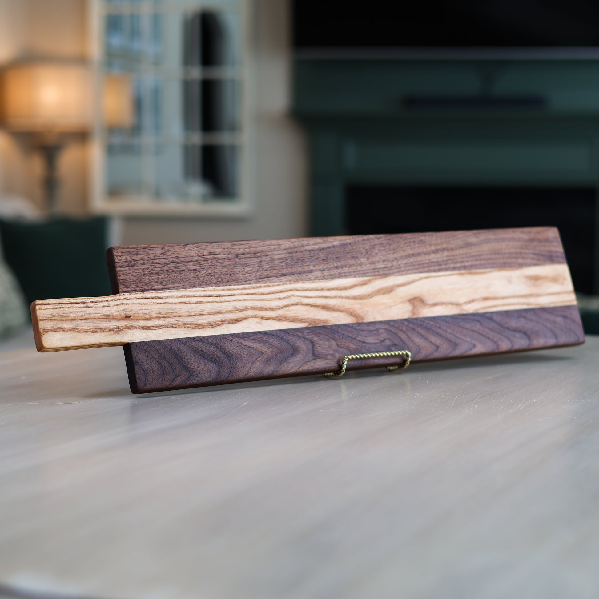 Wooden charcuterie board with purple and brown stripes on a table in a living room