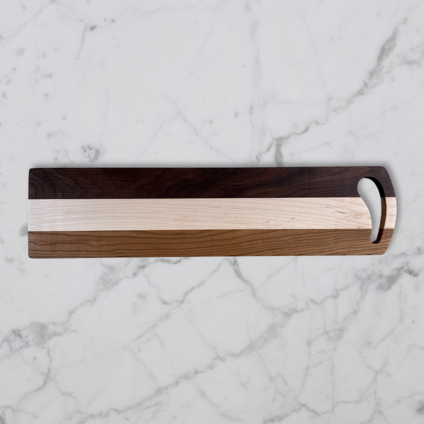 Wooden Charcuterie board with a handle on a marble surface