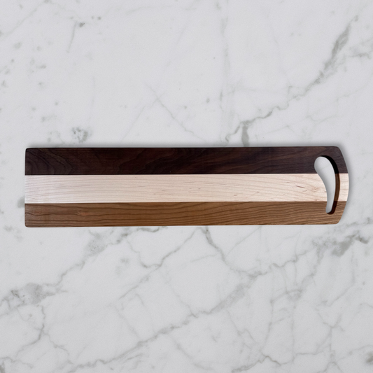 Wooden Charcuterie board with a handle on a marble surface