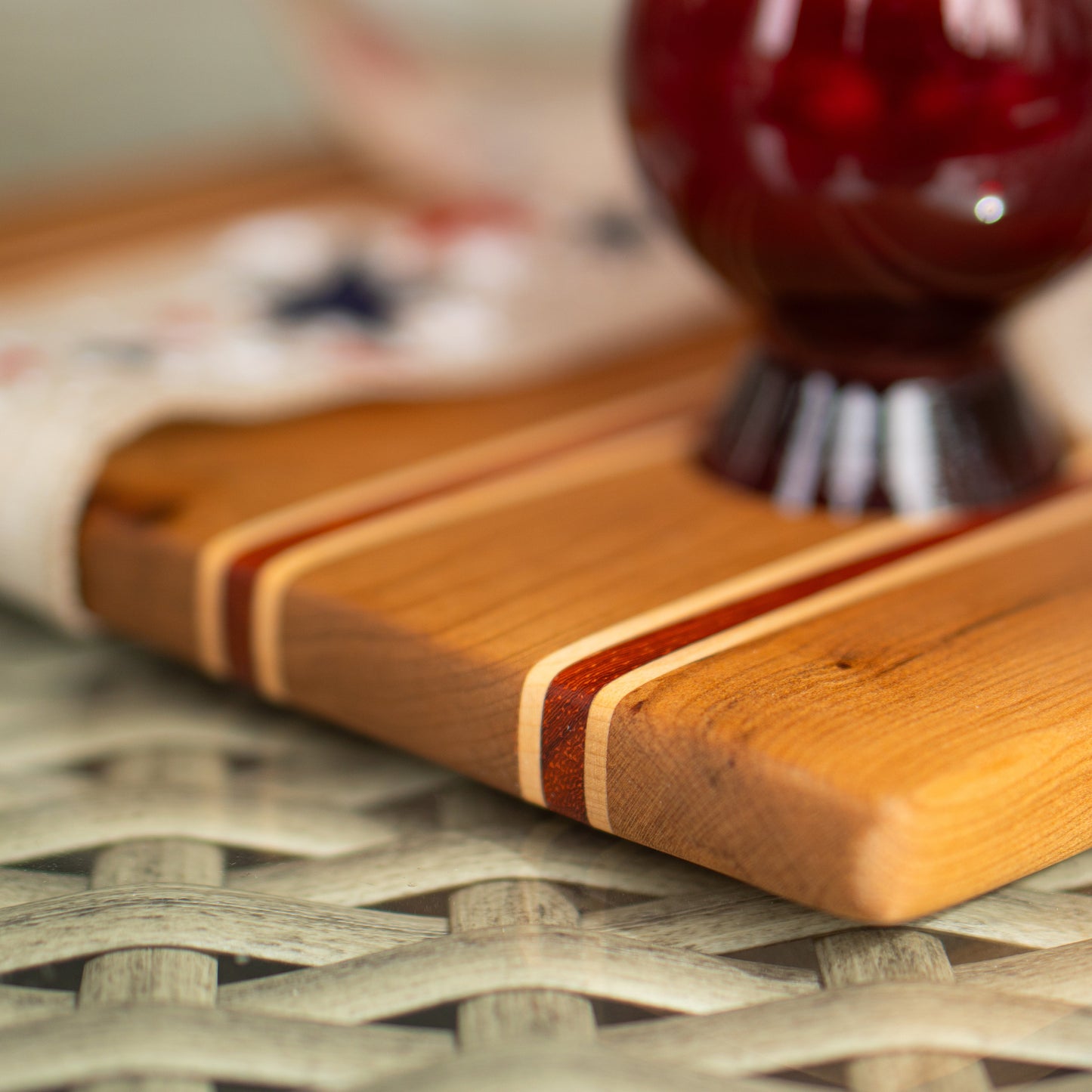 Patriotic wooden bourbon flight board with a red glass item on a woven surface