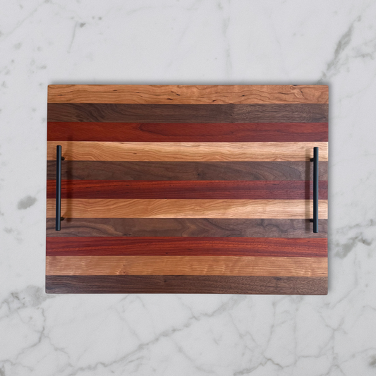 Wooden stove top tray with striped pattern and black handles on a marble surface