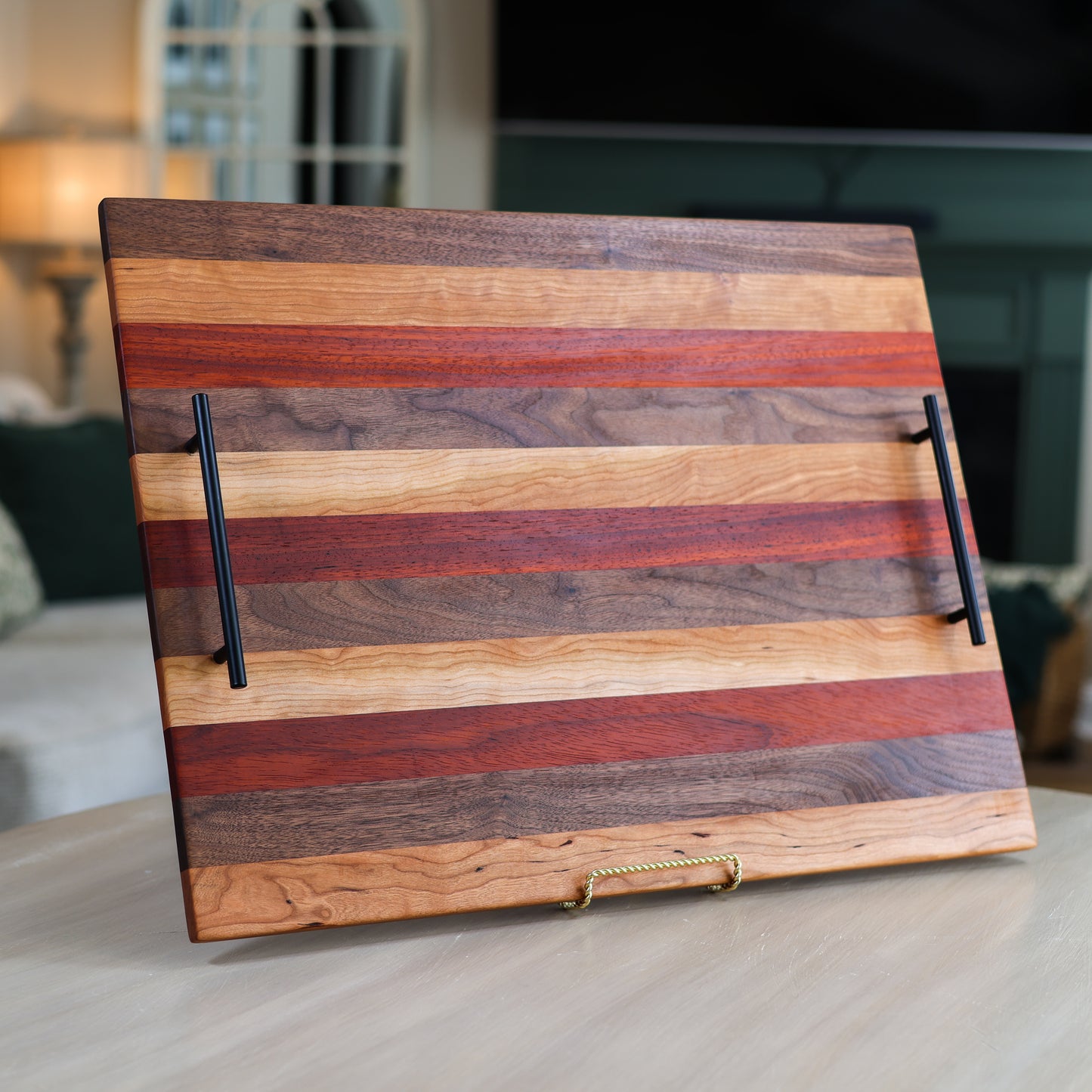 Wooden stove top tray with striped pattern and black handles in a living room
