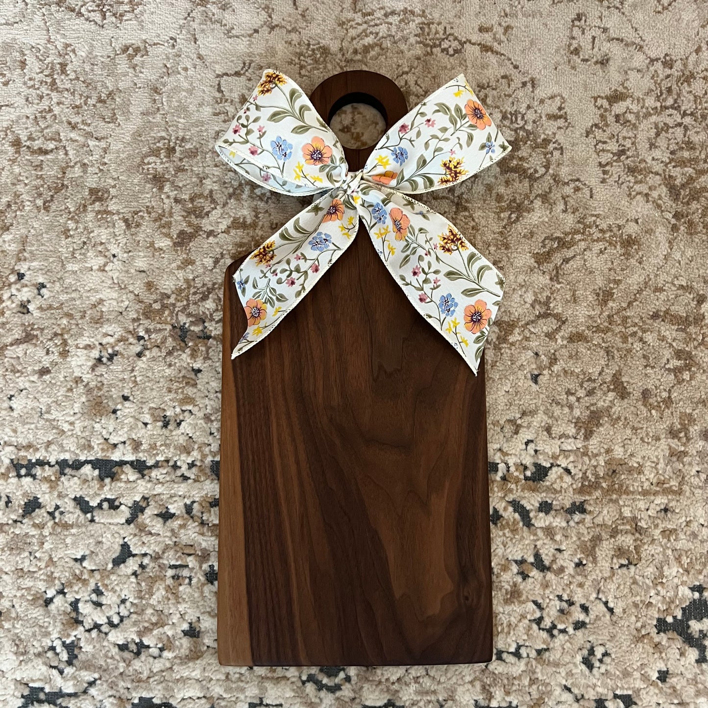 Handcrafted walnut charcuterie board with floral bow, 17.5 inches by 7.75 inches