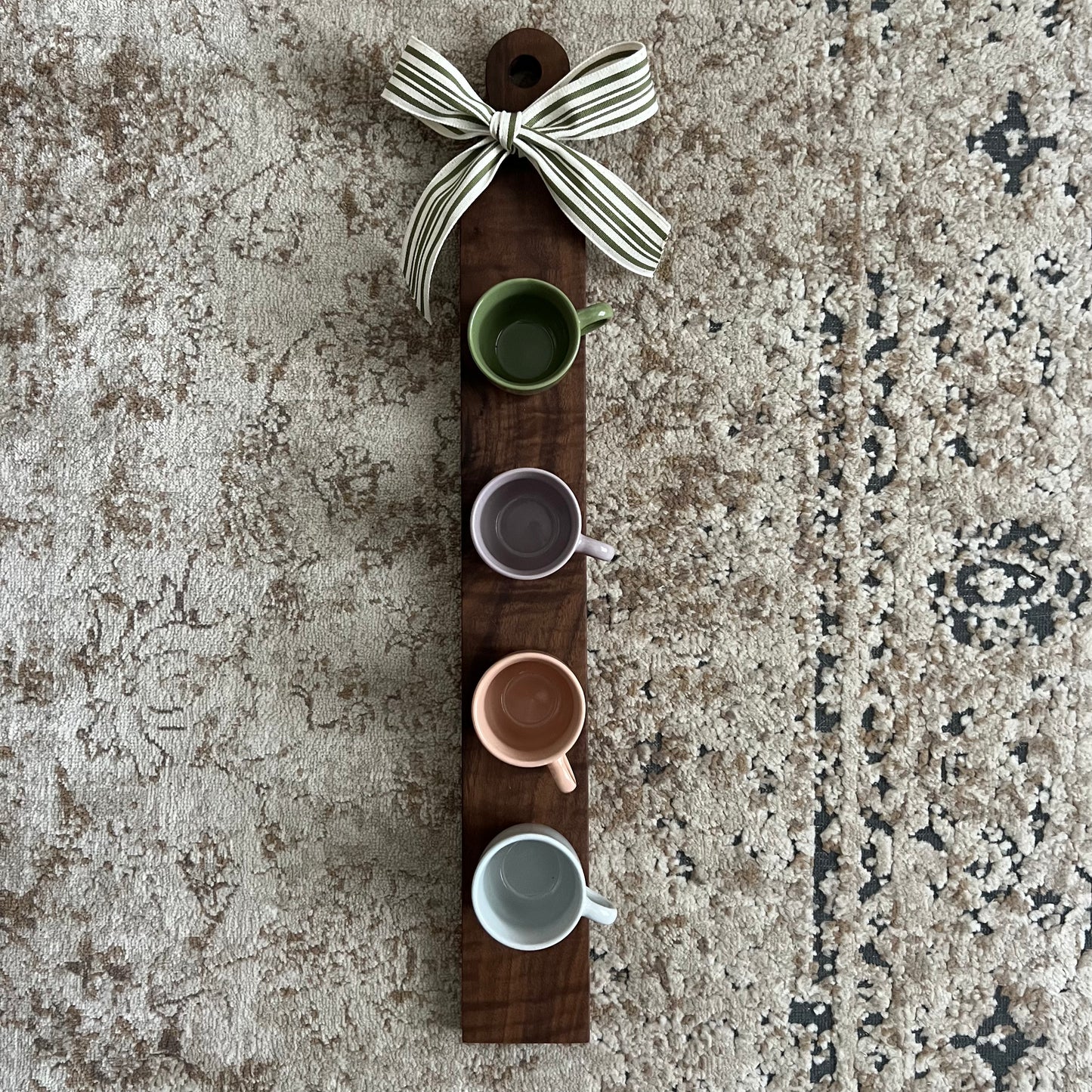 Handcrafted walnut coffee flight board featuring four tasting cups evenly spaced on a long, narrow wooden board.