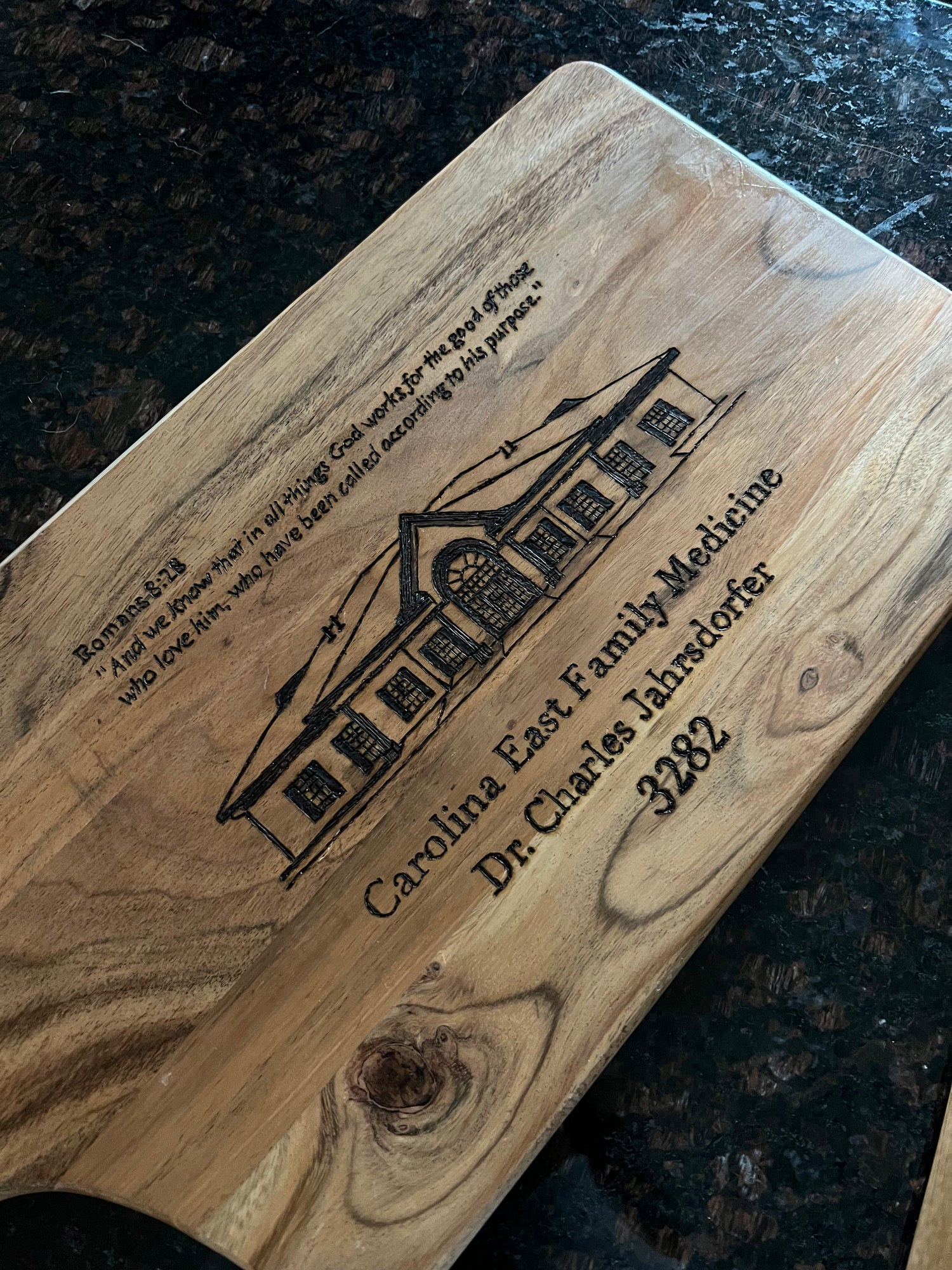 Hand-burned wooden board featuring the Carolina East Family Medicine logo, detailed with precise lettering and design on natural hardwood.