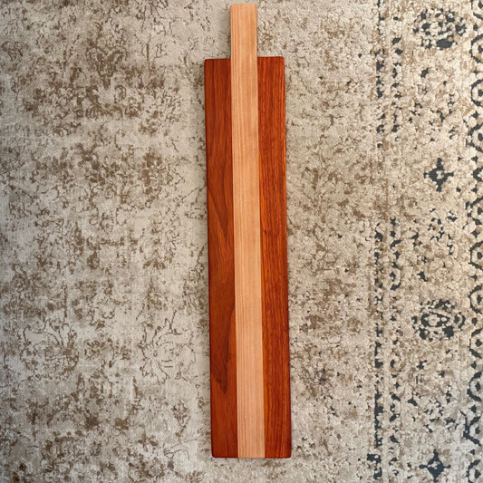 Wooden cutting board with a striped pattern on a textured surface